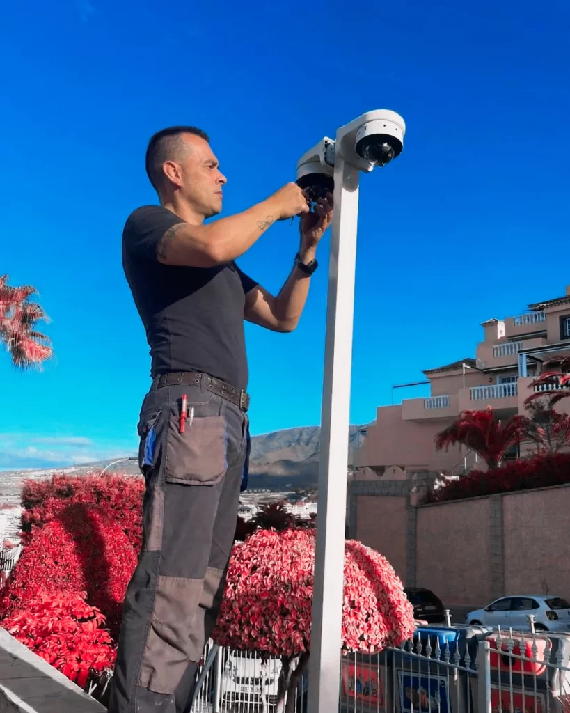 Técnico de TELCONAV instalando y ajustando cámaras de videovigilancia CCTV en exteriores.
